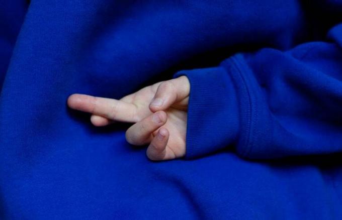 παιδί με σταυρωμένα δάχτυλα πίσω από την πλάτη